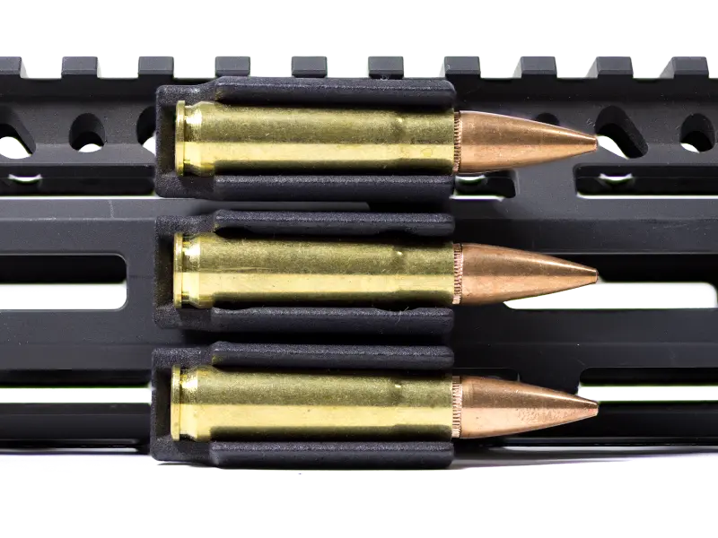 Close-up view of three round chambers showing secure grip on different intermediate caliber cartridges