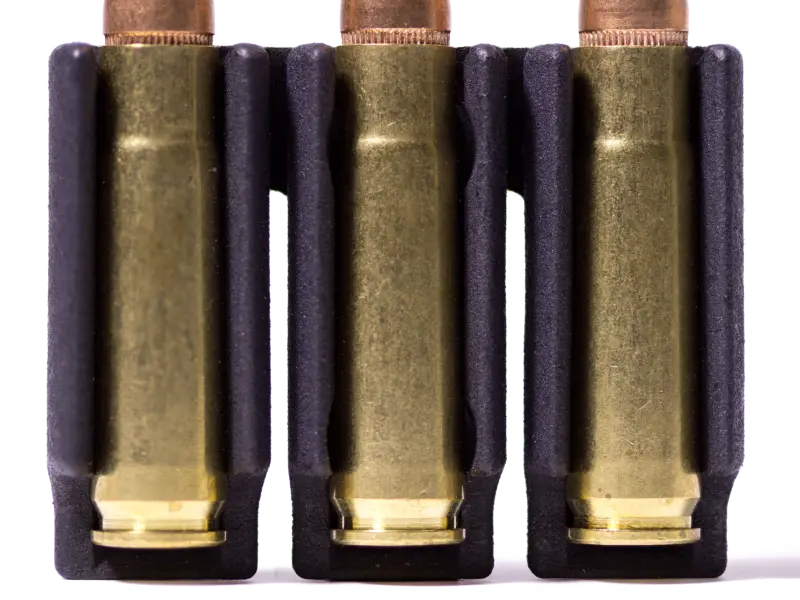 Side view showing slim profile of M-LOK ammo carrier mounted under rifle scope