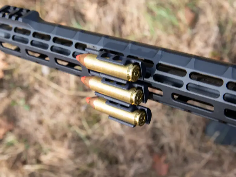 Demonstration of round extraction with heavy hunting gloves showing easy access