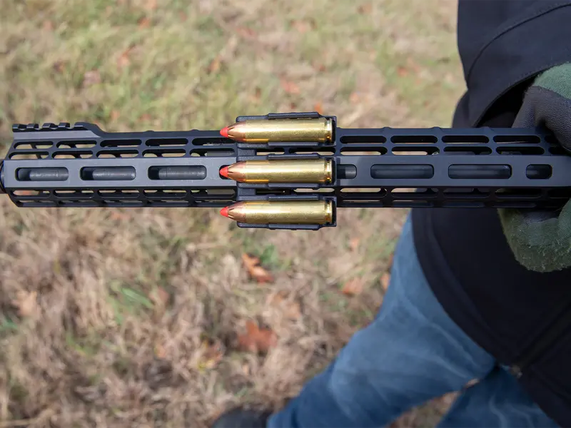 Ammo Carrier for M-LOK rail holding three .450 Bushmaster rounds on a rifle