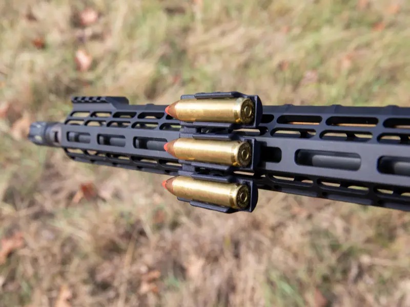 Hunter extracting large caliber round from M-LOK carrier during field use