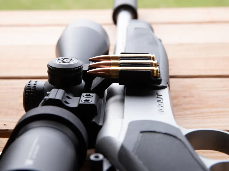 Hunter's rifle setup showing Picatinny ammo carrier positioned for quick access during field use