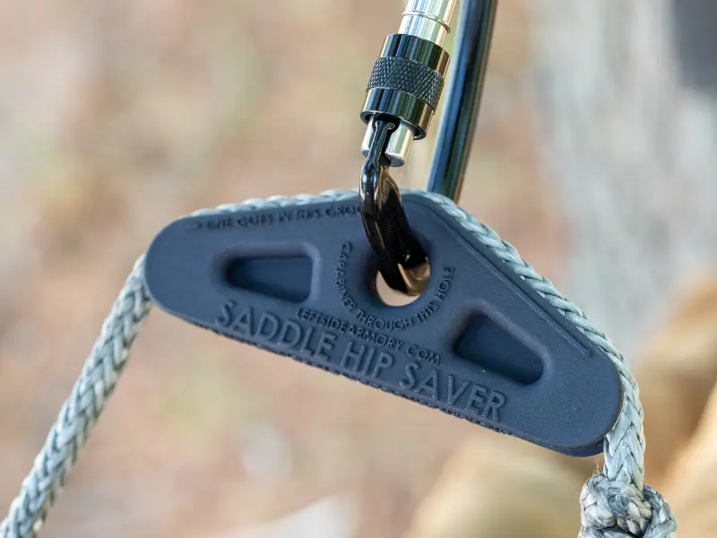 Lightweight black nylon Saddle Hip Saver next to hunting saddle gear