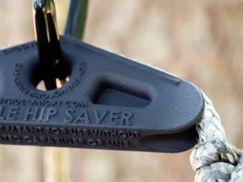 Hunter adjusting Saddle Hip Saver on lineman rope for optimal comfort positioning