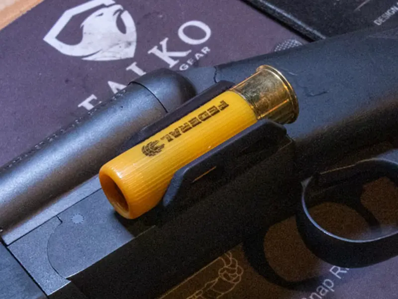 Side view of the shell holder showing its low-profile fit on a shotgun