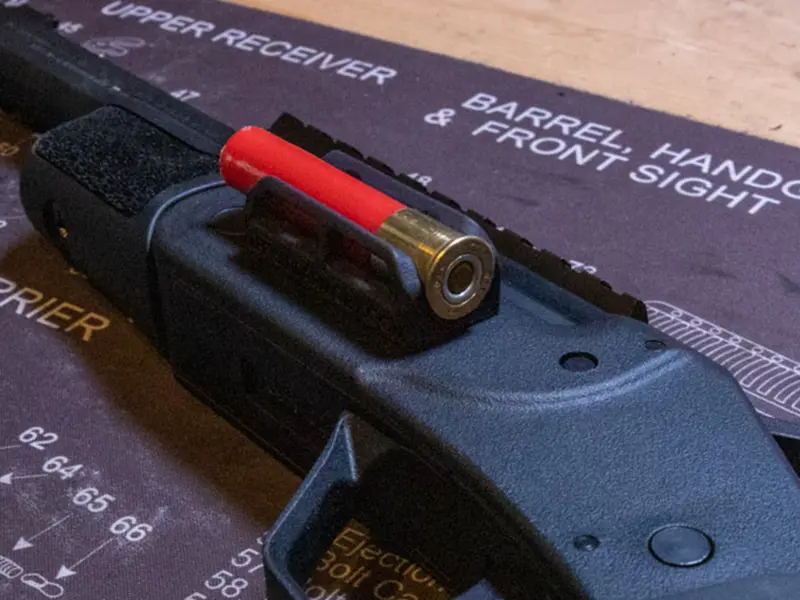 Side view of the shell holder showing its low-profile fit on a shotgun
